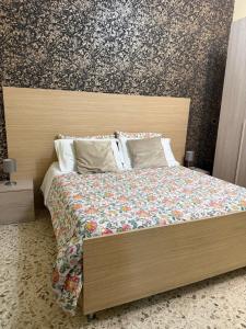 a bedroom with a large bed with a wooden headboard at Pompei Sanctuary rooms in Pompei