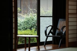 a table and a chair in front of a window at Bob's house in Kameoka