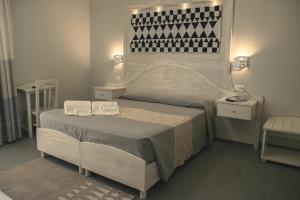 a bedroom with a large bed with two towels on it at Hotel Cala Dei Pini in Porto Pino