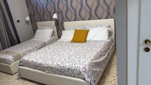 a bedroom with a bed with a yellow pillow at Pompei Sanctuary rooms in Pompei +41 photos
