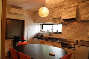 a kitchen with a table and red chairs in it at Bob's house in Kameoka
