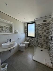a bathroom with a toilet and a sink and a shower at Hotel Cala Dei Pini in Porto Pino