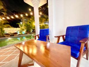 a wooden table and two blue chairs on a patio at Sky Heritage Hotel in Phnom Penh +88 photos