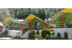 a man and woman standing in front of a row of houses at Thrillomania Kasol in Kasol +13 photos