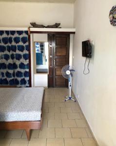 a room with a bed and a fan and a door at OCEAN-SI Mansion in Kribi