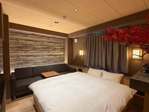 a bedroom with a large bed and a couch at Hatagoyorozu in Sasebo