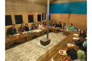 a group of people sitting at tables in a room at Thrillomania Kasol in Kasol