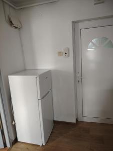 a white refrigerator in a room with a door at Apartament in Geoagiu Băi
