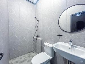 a bathroom with a toilet and a sink and a mirror at X Hostel Jogja in Timuran +13 photos