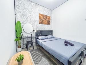 a bedroom with a bed and a desk in it at X Hostel Jogja in Timuran