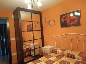 a bedroom with a bed and a mirror at Apartamento Ria de Vegadeo in Vegadeo