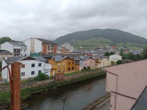 a city with a river and buildings and a mountain at Apartamento Ria de Vegadeo in Vegadeo