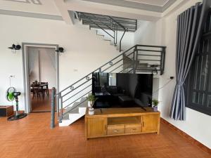 a living room with a tv and a staircase at Mây's Villa in Da Lat +19 photos