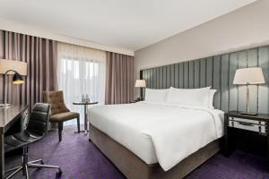 a hotel room with a large bed and a desk and chair at The Trinity City Hotel in Dublin