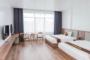 a hotel room with two beds and a table at Long Hải Hotel in Móng Cái +35 photos