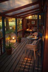 a wooden deck with a table and chairs on it at Chalet Le Puy Papillon in Servières-le-Château
