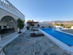 a house with a swimming pool and a patio at Mediterranean Villa Megara in Megara