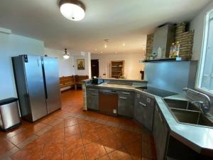 a large kitchen with a stainless steel refrigerator at VILLA SA CALMA in Zaragoza