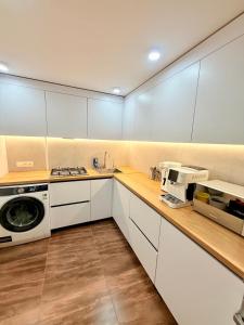 a kitchen with white cabinets and a microwave at Новый Хостел с Кабинками in Chişinău