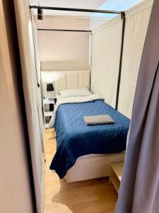 a bedroom with a bed with a blue comforter at Новый Хостел с Кабинками in Chişinău +14 photos
