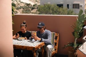 two women sitting at a table eating food at Tasga Guest House in Tamraght Ou Fella