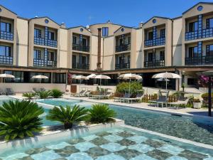 un cortile con piscina di fronte a un edificio di River Park Hotel ad Ameglia