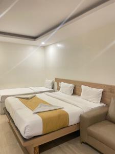 a bedroom with two beds and a couch at hotel fortune city in Bangalore +64 photos