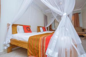 a bedroom with a bed with a canopy at SILVER OAKS HOTEL Boma in Fort Portal