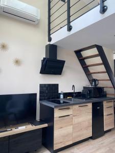 a kitchen with a sink and a black stove at L'atelier Maillot in Évreux