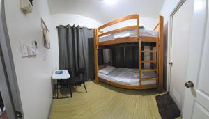 a small room with a bunk bed and a table at Jam Residences in Tagbilaran City