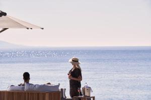 a woman standing on the beach looking at the ocean at Bellevue On The Beach Suites in Rhodes Town