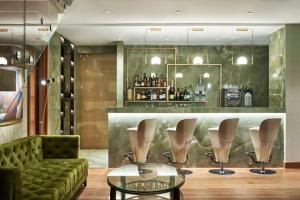 a lobby with a green couch and a bar at Bellevue On The Beach Suites in Rhodes Town