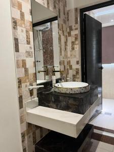 a bathroom with a sink and a large mirror at شقق هذا منزلي المخدومة in Riyadh +67 photos