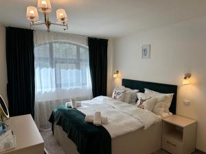 a bedroom with a large bed and a window at Cerbul Chalét Accommodation & Wellness in Râşnov +24 photos