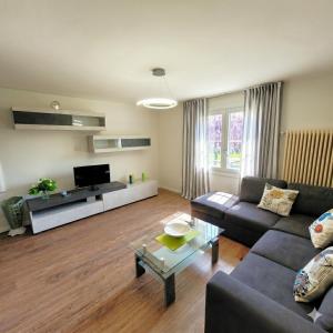 a living room with a couch and a tv at Garden Relais Mountain Lake Iseo Hospitality in Solto Collina