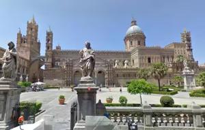 a large building with a statue in front of it at Casa Normanna in Palermo