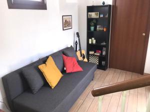 a gray couch with colorful pillows in a living room at Casa Normanna in Palermo