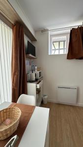 a room with a table and a kitchen with a bed at Chambres mimi deni in Hésingue
