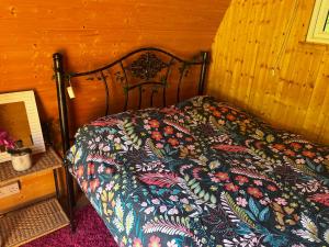 a bed with a colorful comforter in a room at Daisy in Battle