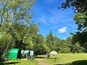 a campsite with a green trailer in a field at Daisy in Battle