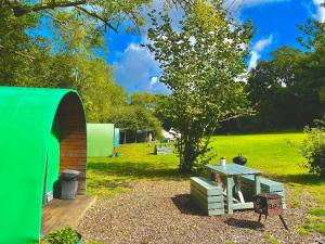 a picnic table and a green tent in a field at Daisy in Battle