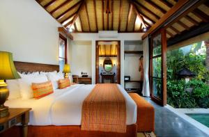 a hotel room with a large bed and a large window at Aradhana Villas by Ekosistem in Canggu