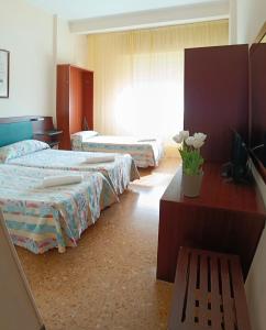 a hotel room with two beds and a window at Hotel Robinia in Imperia