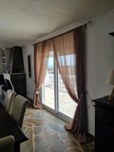 a living room with a large window with curtains at Mediterranean Villa Megara in Megara