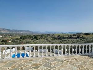 a white fence with blue chairs on a patio at Mediterranean Villa Megara in Megara