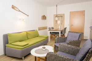a living room with a couch and chairs and a table at FineApartment Alt Duvenstedt in Alt Duvenstedt