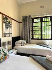 a bedroom with two beds and a window at A Sunflower Stop Backpackers in Cape Town +63 photos