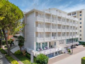 an apartment building with white balconies and trees at Hotel Danieli in Bibione