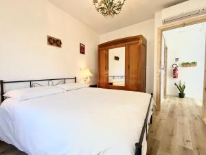 a bedroom with a white bed and a chandelier at Locanda dei Gelsomini in Civitella Del Lago