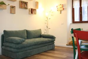 a green couch sitting in a living room at Locanda dei Gelsomini in Civitella Del Lago